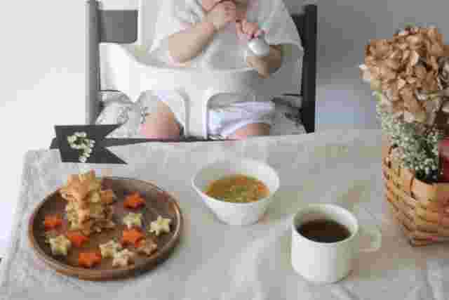 離乳食を食べる赤ちゃんとテーブルの上に並んだ離乳食