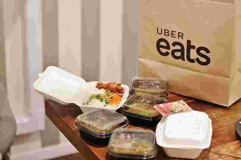 ウーバーイーツの紙袋とデリバリーした料理の数々