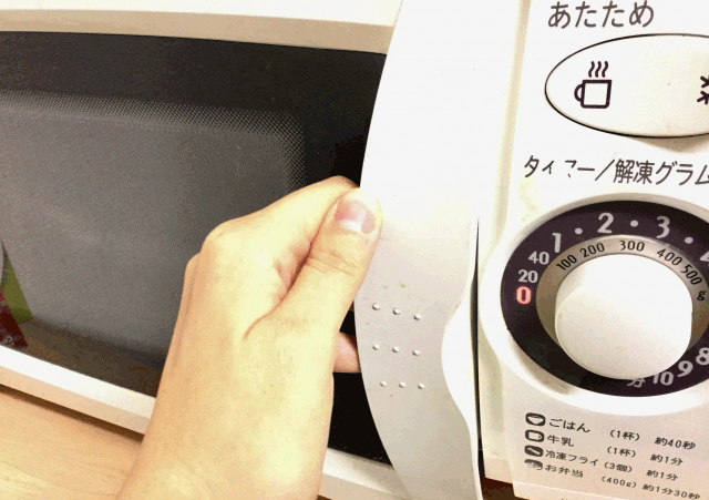 電子レンジの扉を開けようとしている様子
