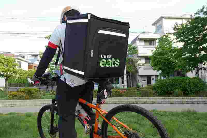 ウーバーイーツ配達員が自転車で、配達している様子