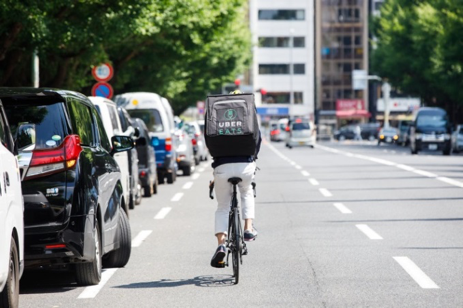 自転車でウーバーイーツ配達員が配達している様子