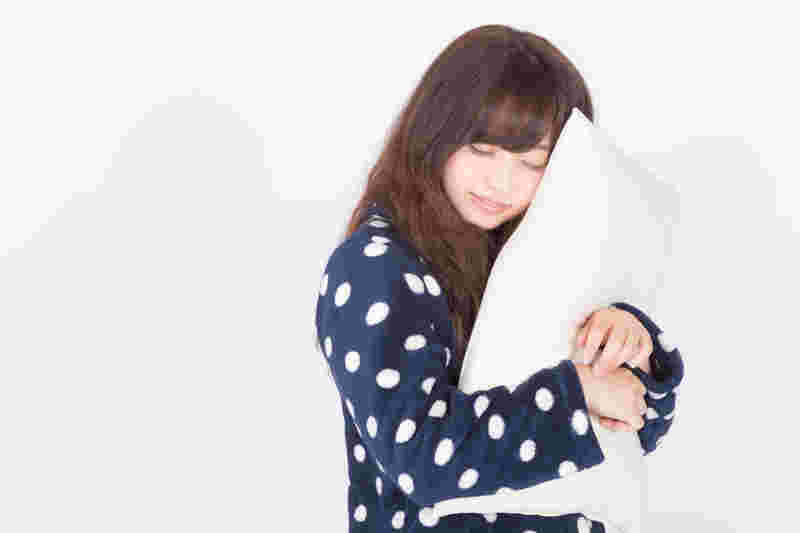 枕をかかえている女性