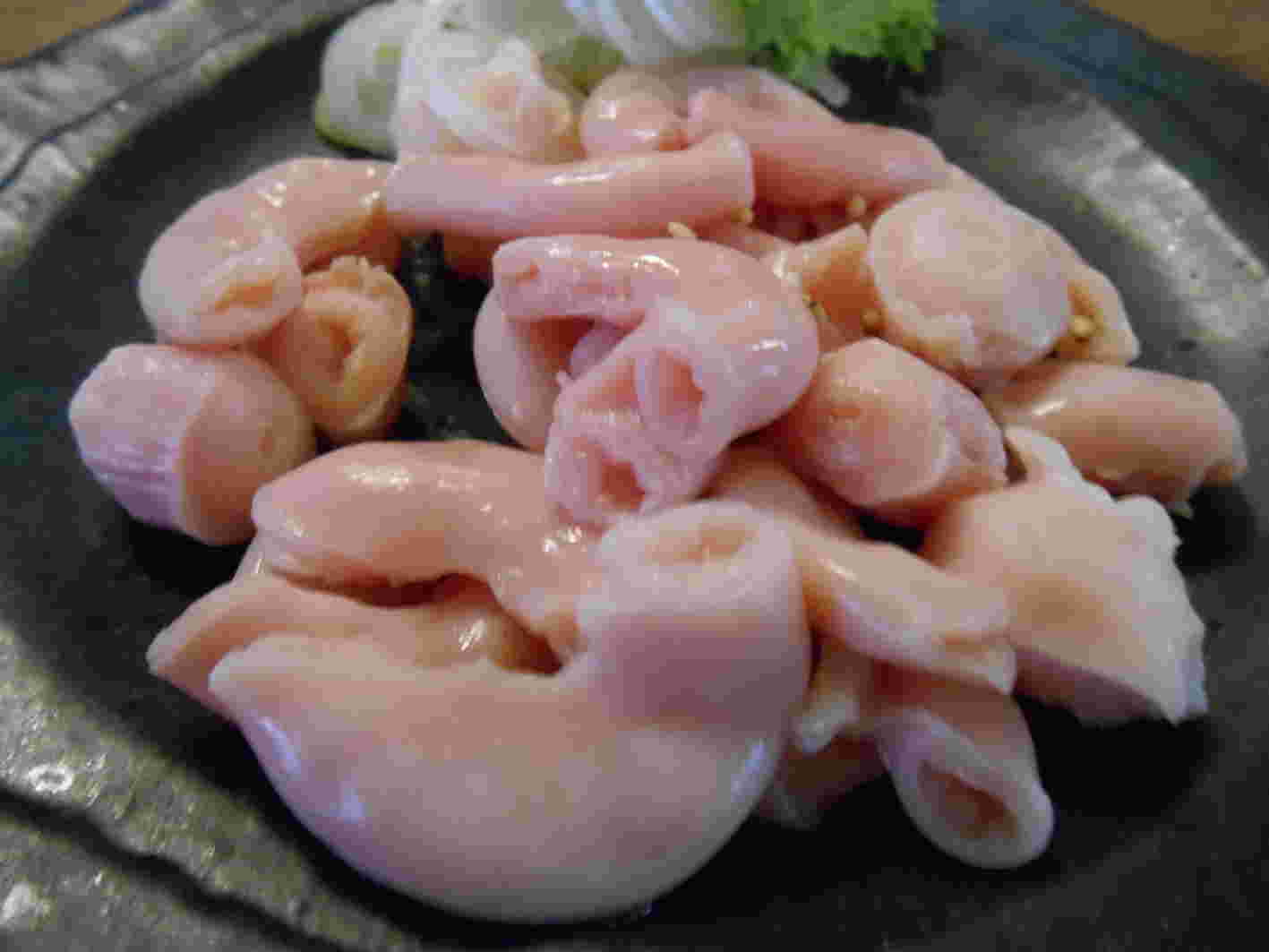 綺麗なピンク色のコブクロをたくさんのせた黒い皿