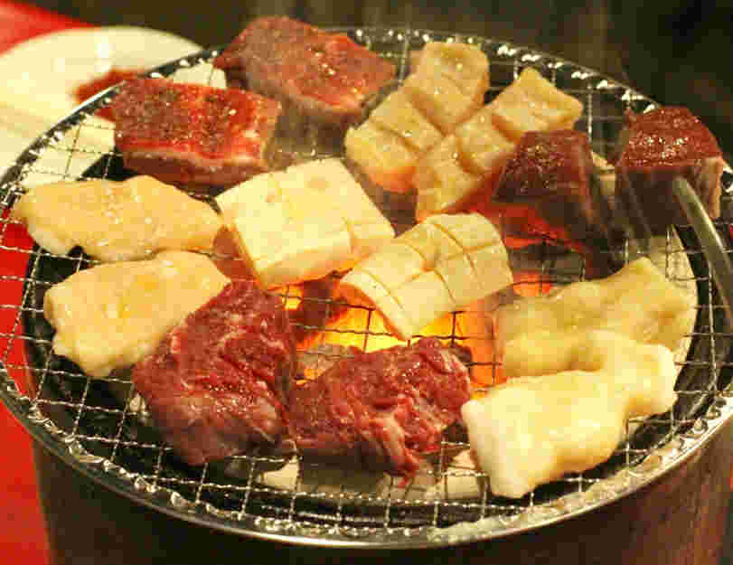 炭火で焼かれているいろいろな種類のもつ