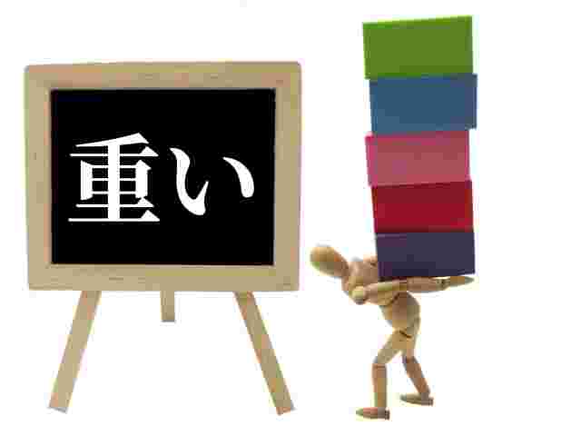 沢山の荷物持って重そうな人形と重いと書かれているプレート
