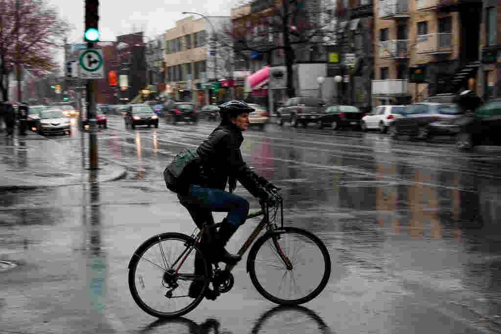 雨の中自転車を運転している外人の女性