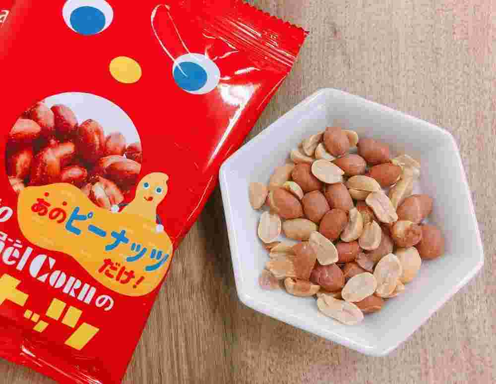 赤い袋のお菓子と白いお皿に入ったピーナッツ