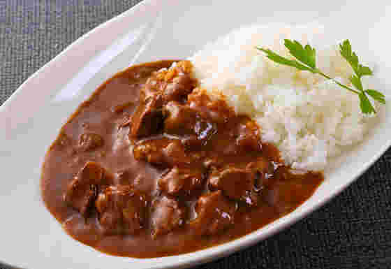 白い楕円形のお皿に白米とカレー