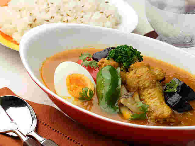 白と赤の器に入ったカレーと白いお皿の上にライス