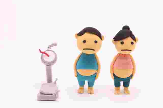 壊れた体重計と悲しい顔の男女