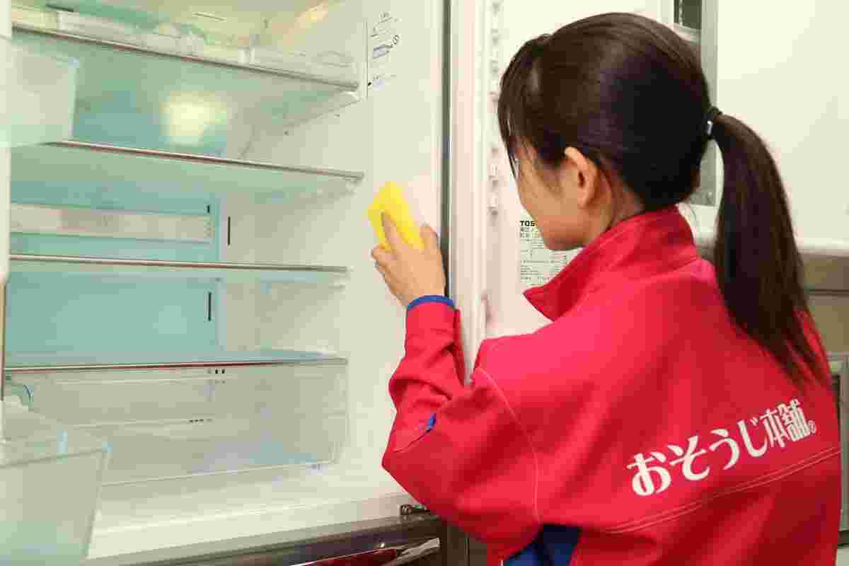 クリーニングサービス業者が冷蔵庫を掃除している