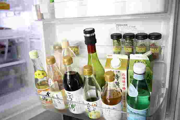 冷蔵庫の横のスペースに液体調味料を入れている写真