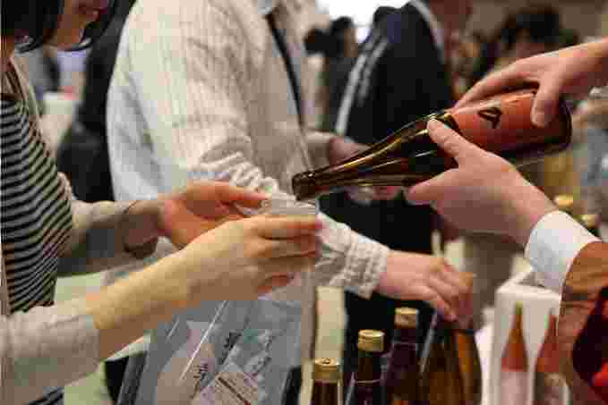 女性にグラスにお酒を注いでいる