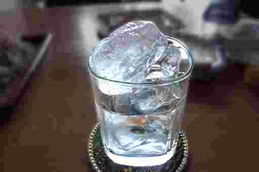 焼酎と氷が入ったグラスがテーブルに置かれている様子