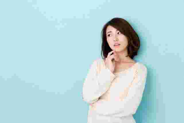 手を顎に添えて考えこむ女性