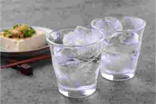 焼酎を注がれた2つのグラスとおつまみの冷奴