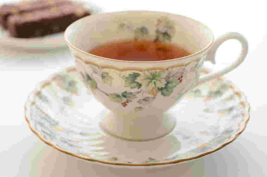 綺麗な絵柄のティーカップに紅茶が注がれ、取っ手が右側に置かれている