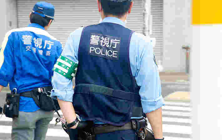 道路で立つ後姿の警察官