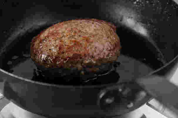 鉄鍋でハンバーグを焼いている