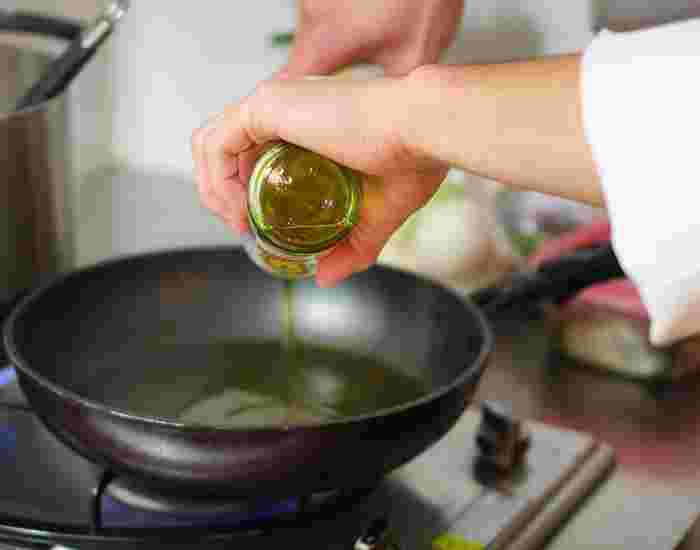 鉄鍋にオリーブオイルを入れている様子