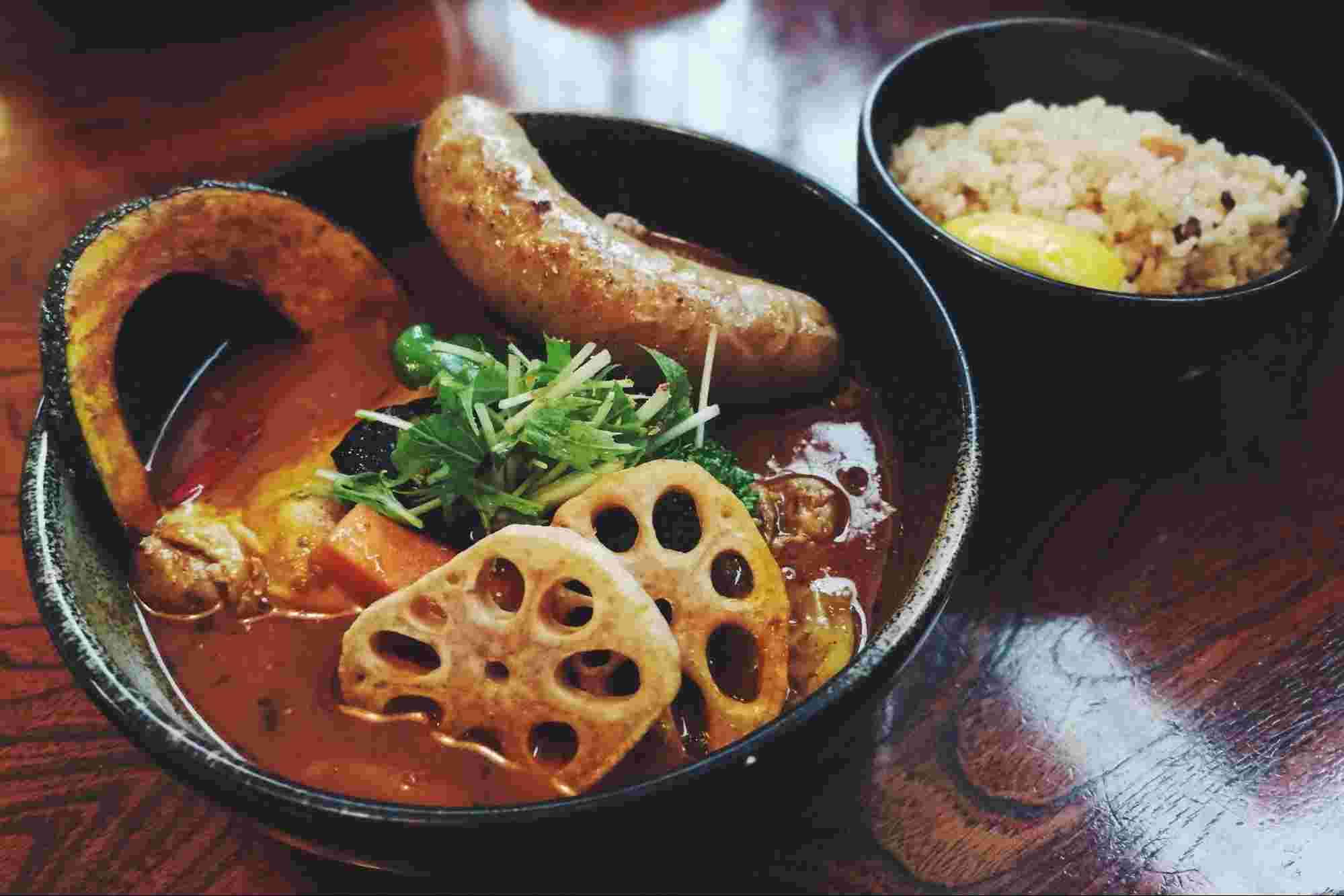 黒いお皿に雑穀米とスープカレーにのったれんこん