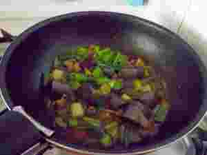 フライパンで韓国スンデとねぎのカレー炒めを作っている様子