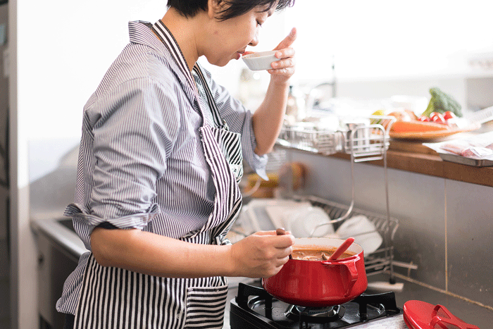 小皿で味見をする女性