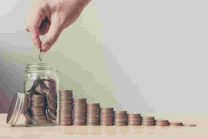 瓶にお金を入れて節約しているイメージ