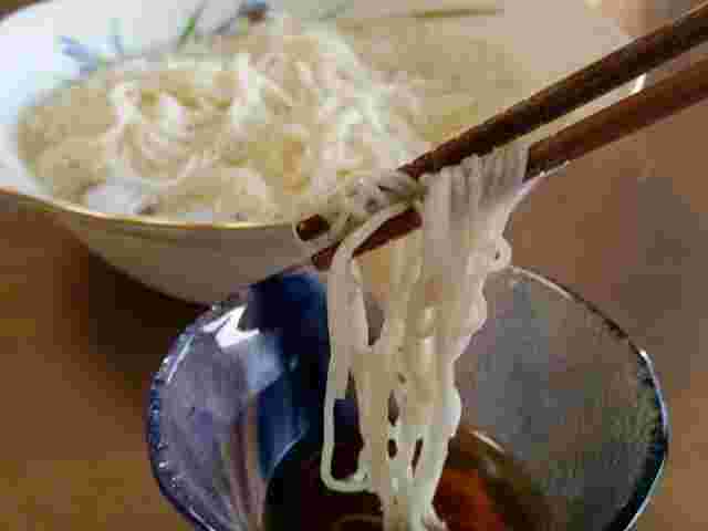 そうめんを麺つゆにつける様子