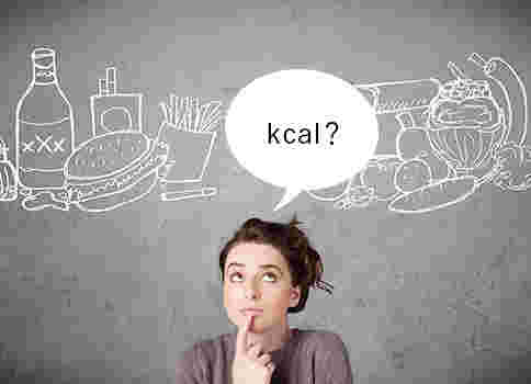 上を向いて人差し指を顎に当てている女性とkcal？の文字
