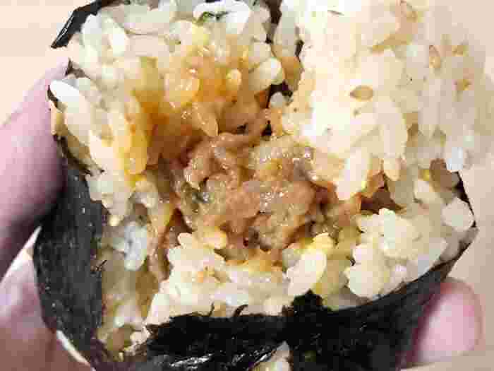 おにぎりを手にとって割って具材を見せている様子。