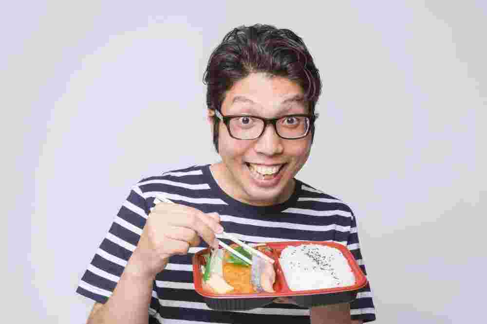 笑顔でお弁当を持っている男性の様子