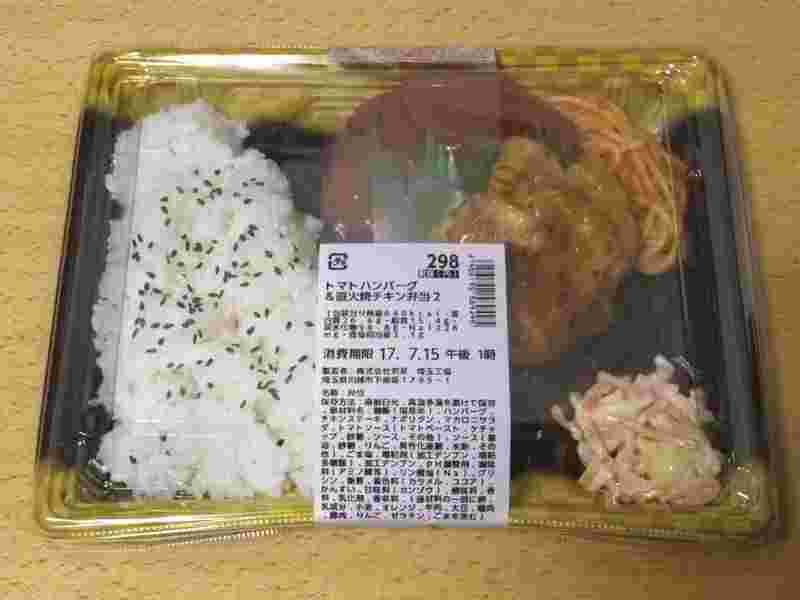 トマトハンバーグ＆直火焼チキン弁当がテーブルに置かれている様子