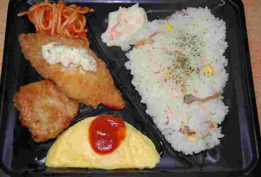 オムレツに魚フライや揚げ物、ピラフが入ったお弁当の様子