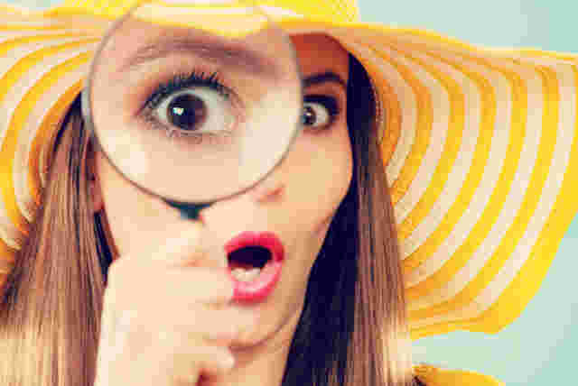 虫眼鏡を覗いてビックリしている外人女性の様子