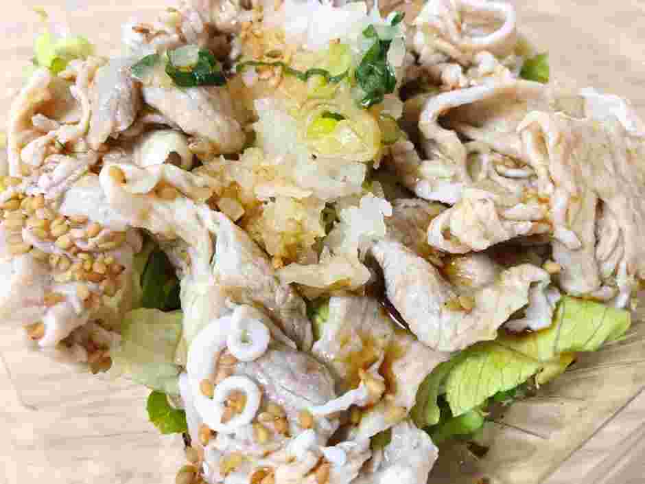 湯がいている肉、キャベツ、ネギ、ゴマ、タレが混ぜ合わさって器に盛られていて美味しそう