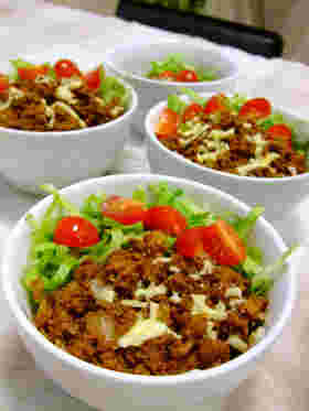 タコライスを盛り付けた丼が4つ並んでいる