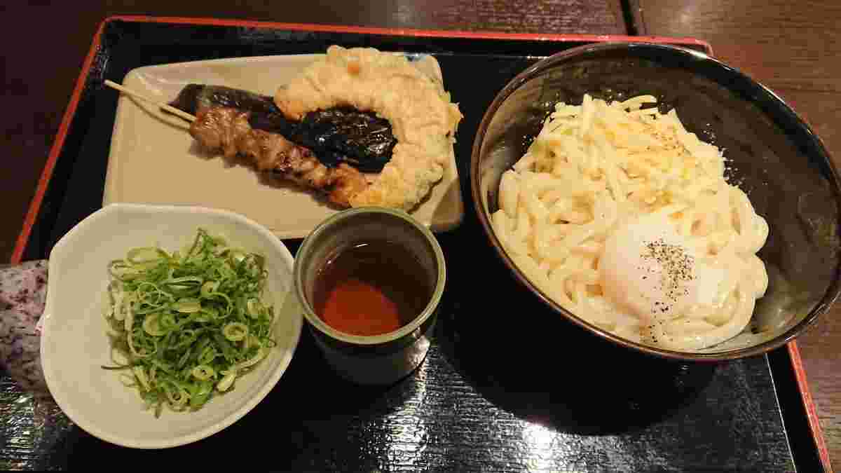 炙りチーズうどんと焼き鳥と天ぷらと小皿に盛ったねぎ