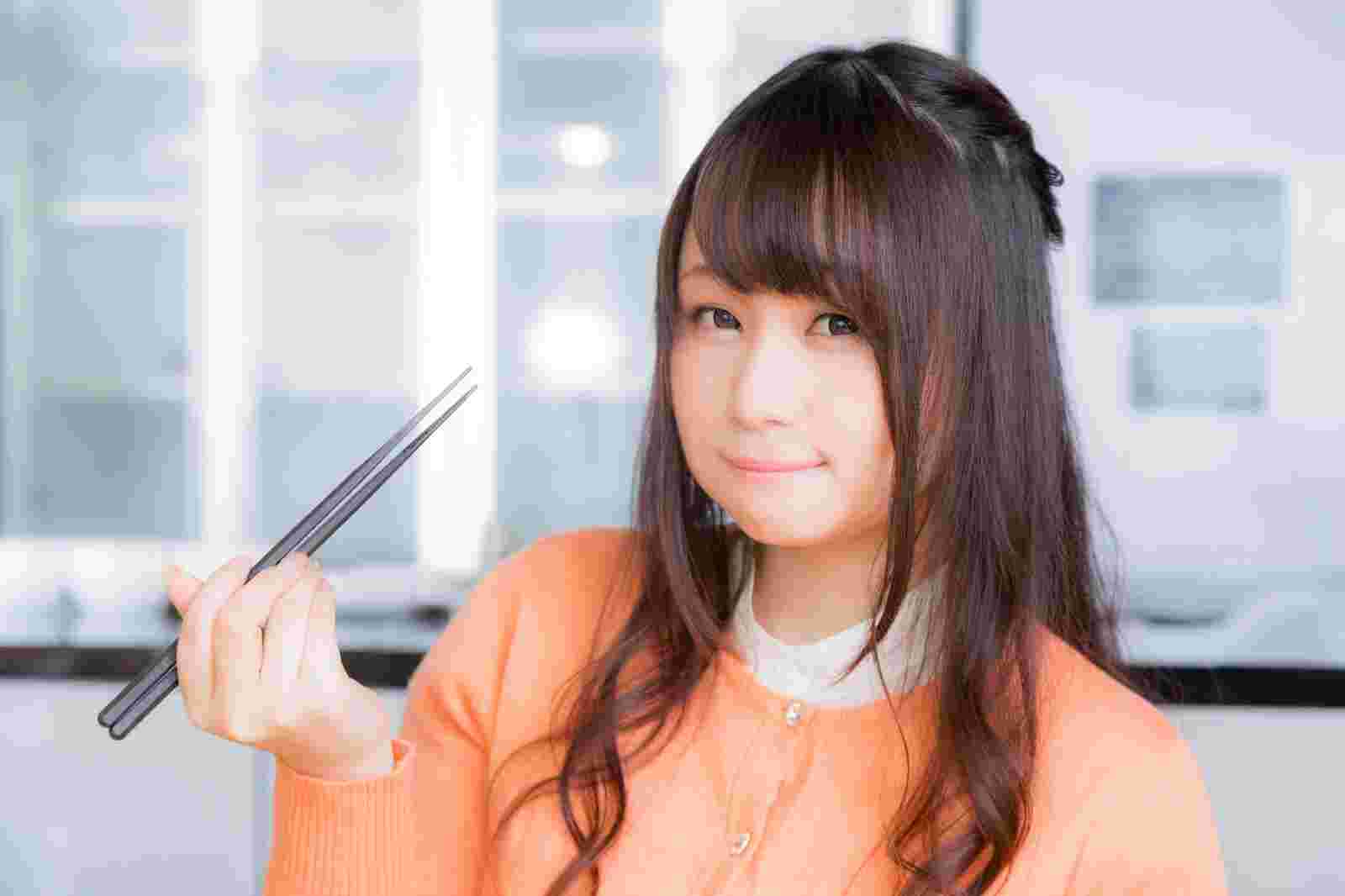 箸を使ったよく噛んで食べる女性