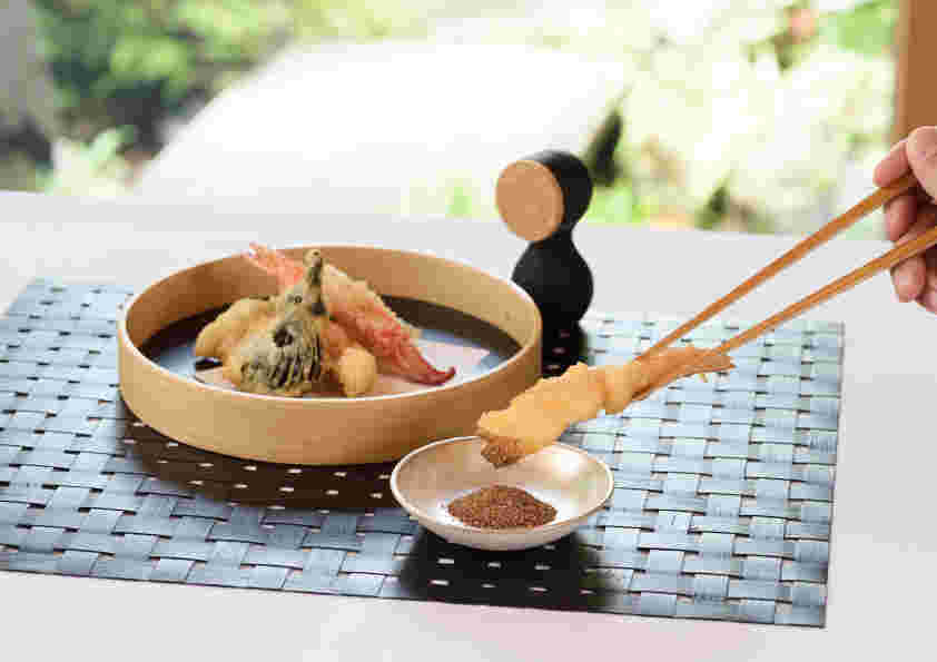 天ぷらに粉末醤油を付けている様子