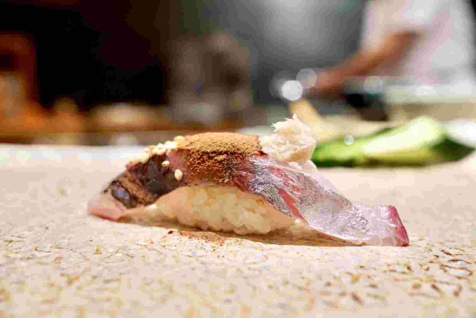 寿司に粉末醤油をかけている