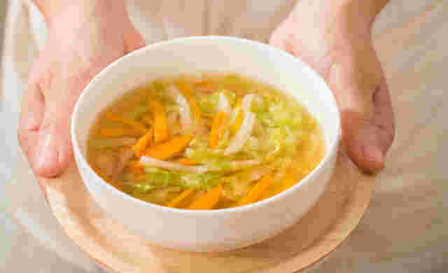 消化に良い野菜を使った、野菜スープを差し出す