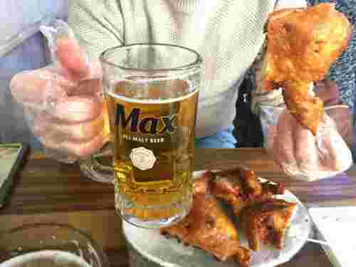 ビール片手にチキンを食べる人