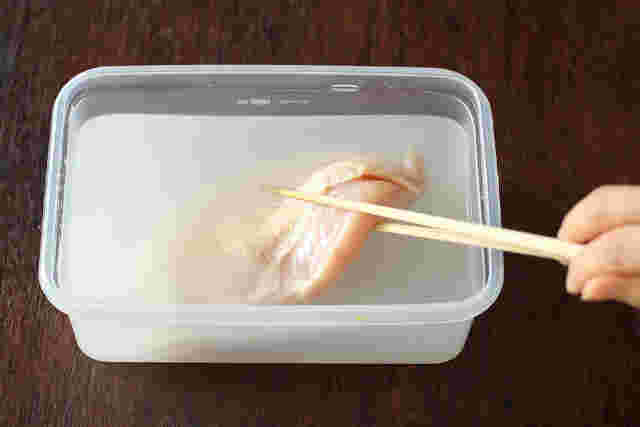 保存容器にブライン液をいれ、鶏むね肉を入れているところ