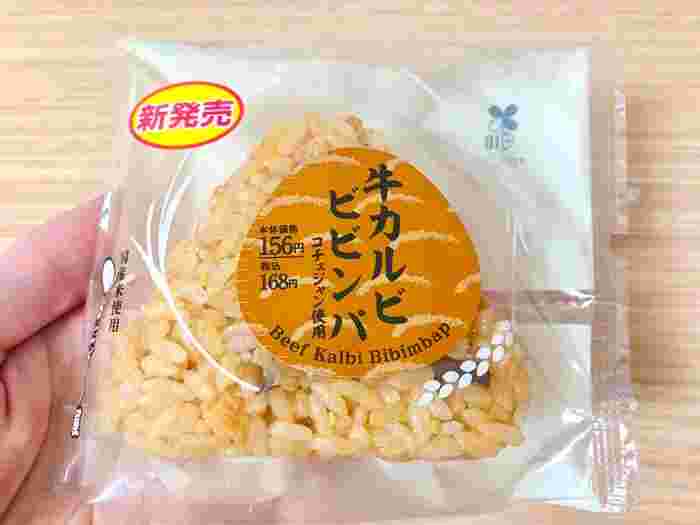 袋に入っているおにぎりを手にとってパッケージデザインを見せている様子。