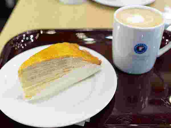 茶色いトレイの上にコーヒーとミルクレープ