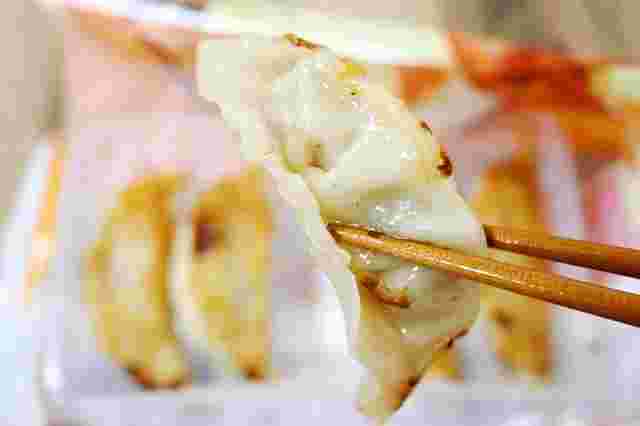 餃子をお箸でつまんだ画像