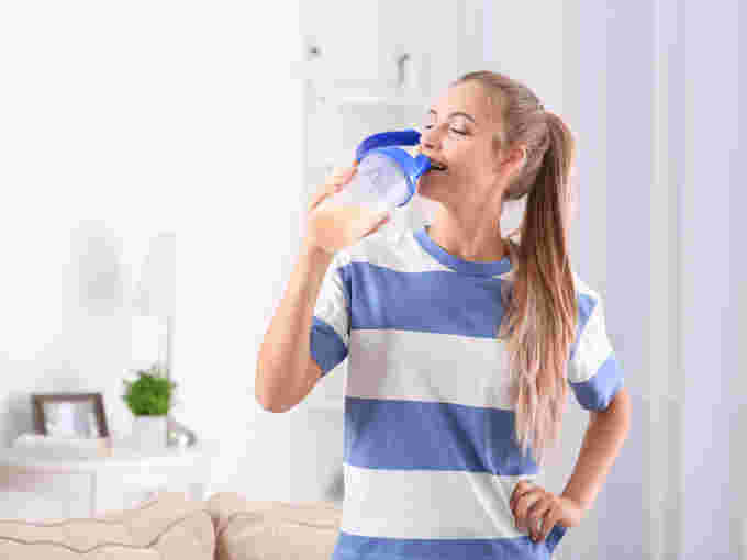プロテインを飲む笑顔の女性