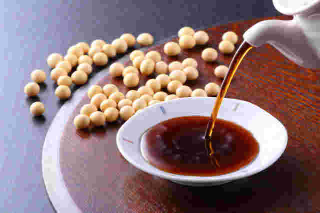 小皿に注がれている醤油と、原料である大豆