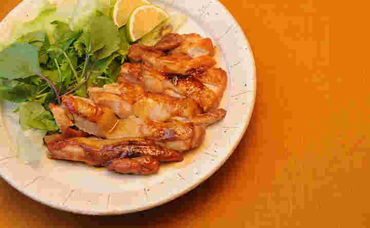 カットして盛り付けた鶏の照り焼きと添えられた野菜とレモン